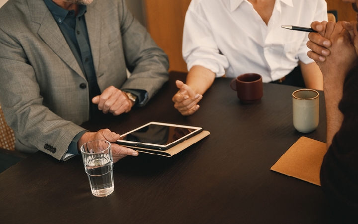 People sitting at a table with a tablet